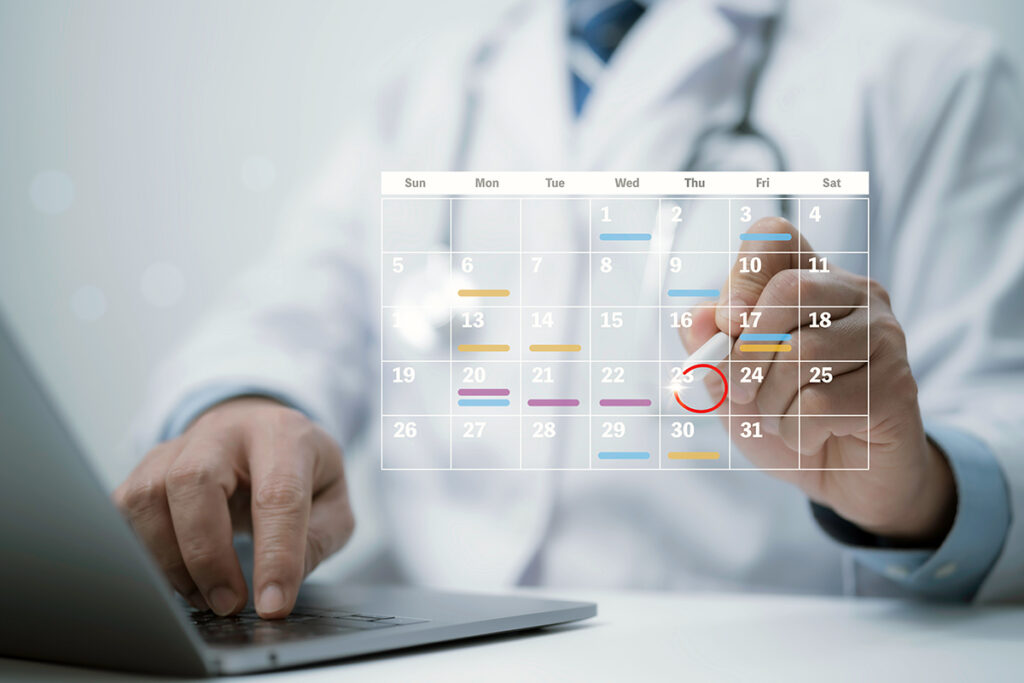 Dentist planning goals and appointments on a digital calendar for dental practice success.